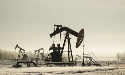 field-with-oil-pump-jacks-surrounded-by-greenery-sunlight-min-scaled_68233ec7d4b99